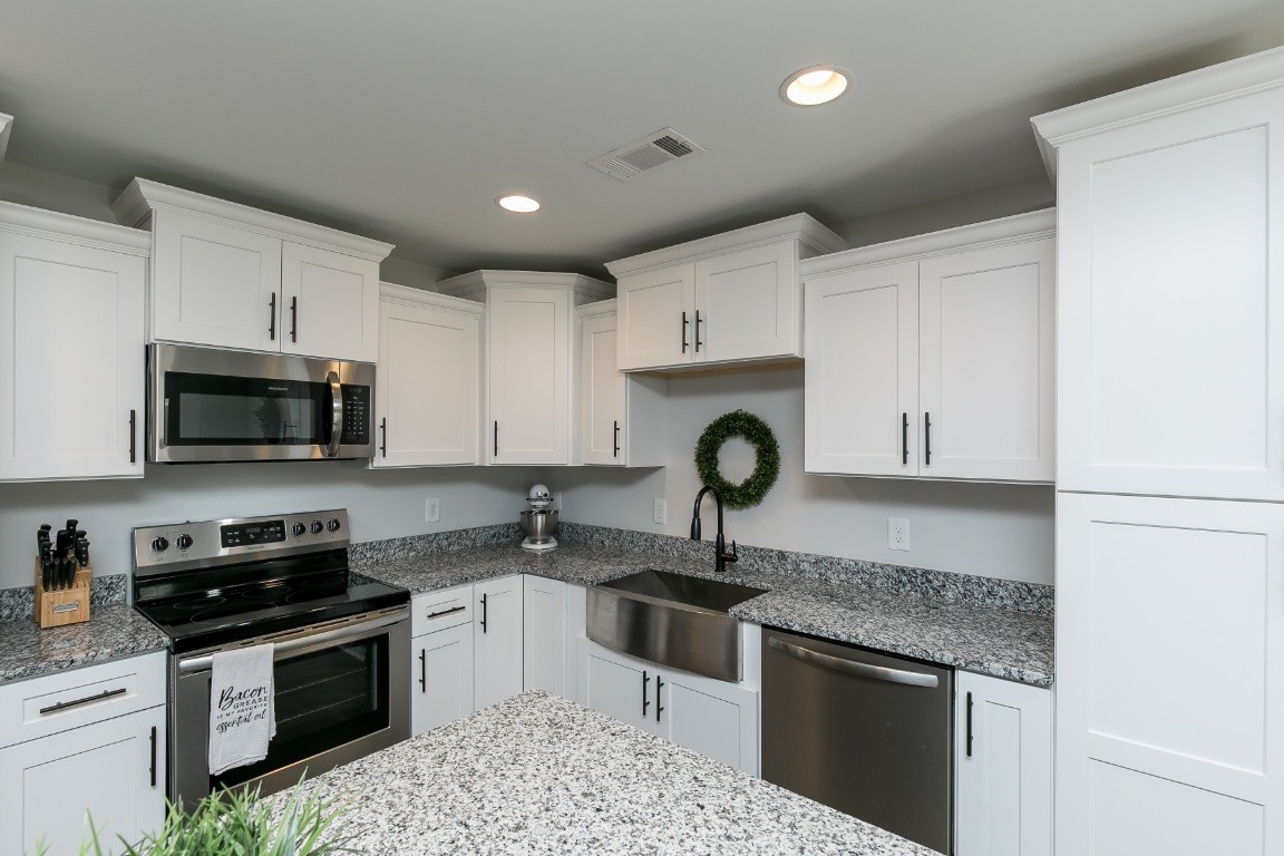 272 Signature Place Lebanon, TN 37087 - Photo 12 of 36 a kitchen with kitchen island granite countertop a sink stainless steel appliances and white cabinets