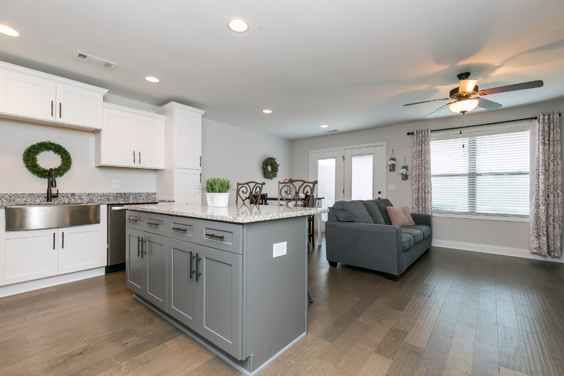 272 Signature Place Lebanon, TN 37087 - Photo 7 of 36 a kitchen with stainless steel appliances granite countertop a sink dishwasher stove and white cabinets with wooden floor