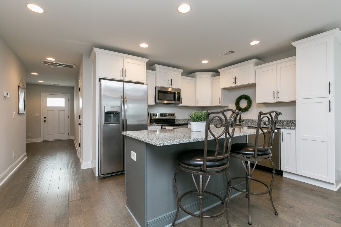 272 Signature Place Lebanon, TN 37087 - Photo 8 of 36 a kitchen with kitchen island granite countertop a refrigerator stove microwave and cabinets