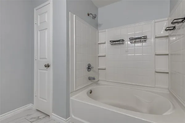a white bath tub sitting next to a white sink and vanity