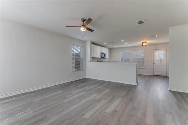 a view of a kitchen with a microwave and wooden floor