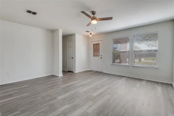 wooden floor in an empty room with a window