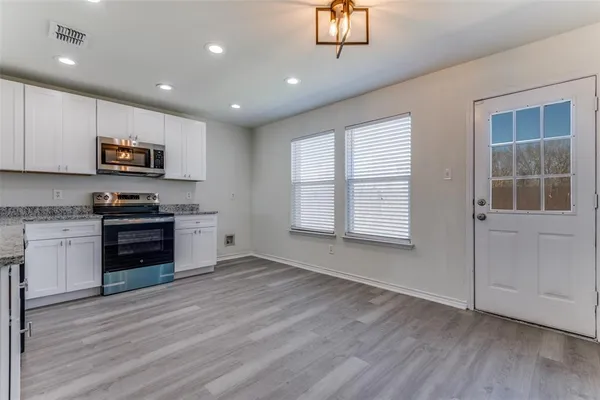 a kitchen with a refrigerator and a stove top oven