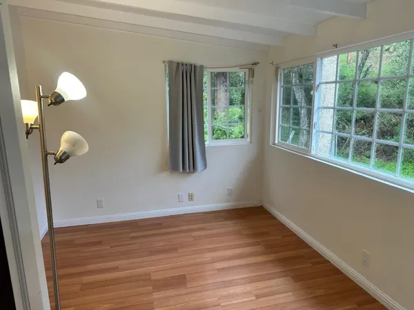 a view of a room with wooden floor and windows