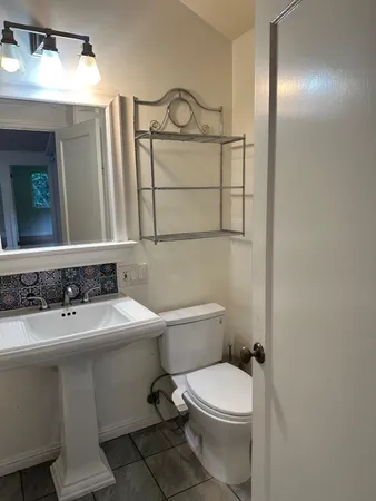 a bathroom with a sink toilet and mirror