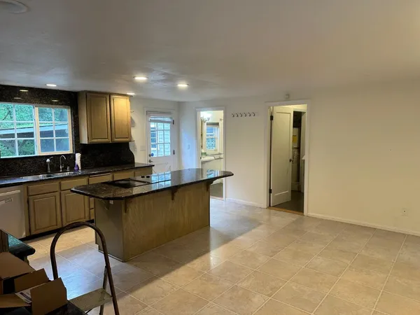 a kitchen with granite countertop a stove a sink and a refrigerator