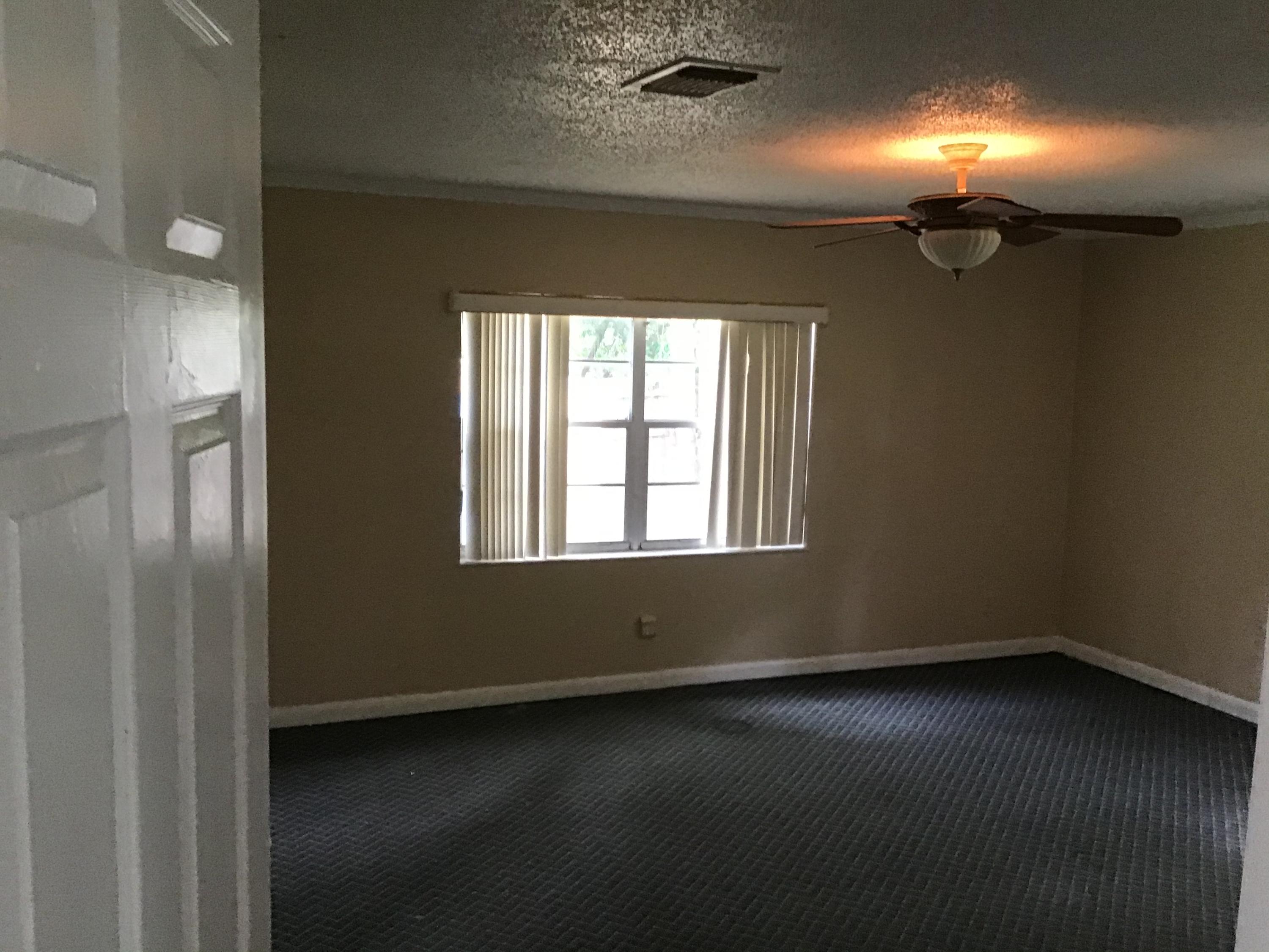 1116 Colonial Road Fort Pierce, FL 34950 - Photo 6 of 19 an empty room with wooden floor and windows