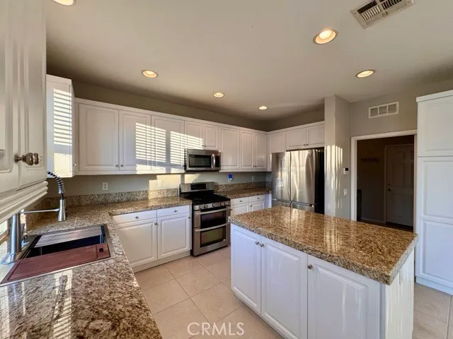 a kitchen with stainless steel appliances granite countertop a refrigerator and a sink