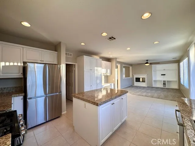 a kitchen with granite countertop a sink and white cabinets