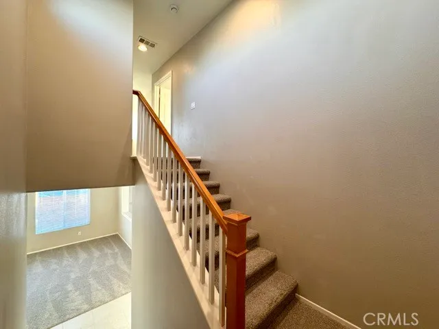 a view of staircase with lots of frames on wall and a window