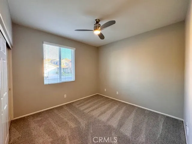 an empty room with closet and windows