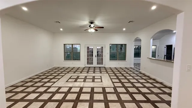 a view of a big room with windows and chandelier fan