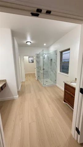 a bathroom with a granite countertop sink a shower a mirror and a bathtub