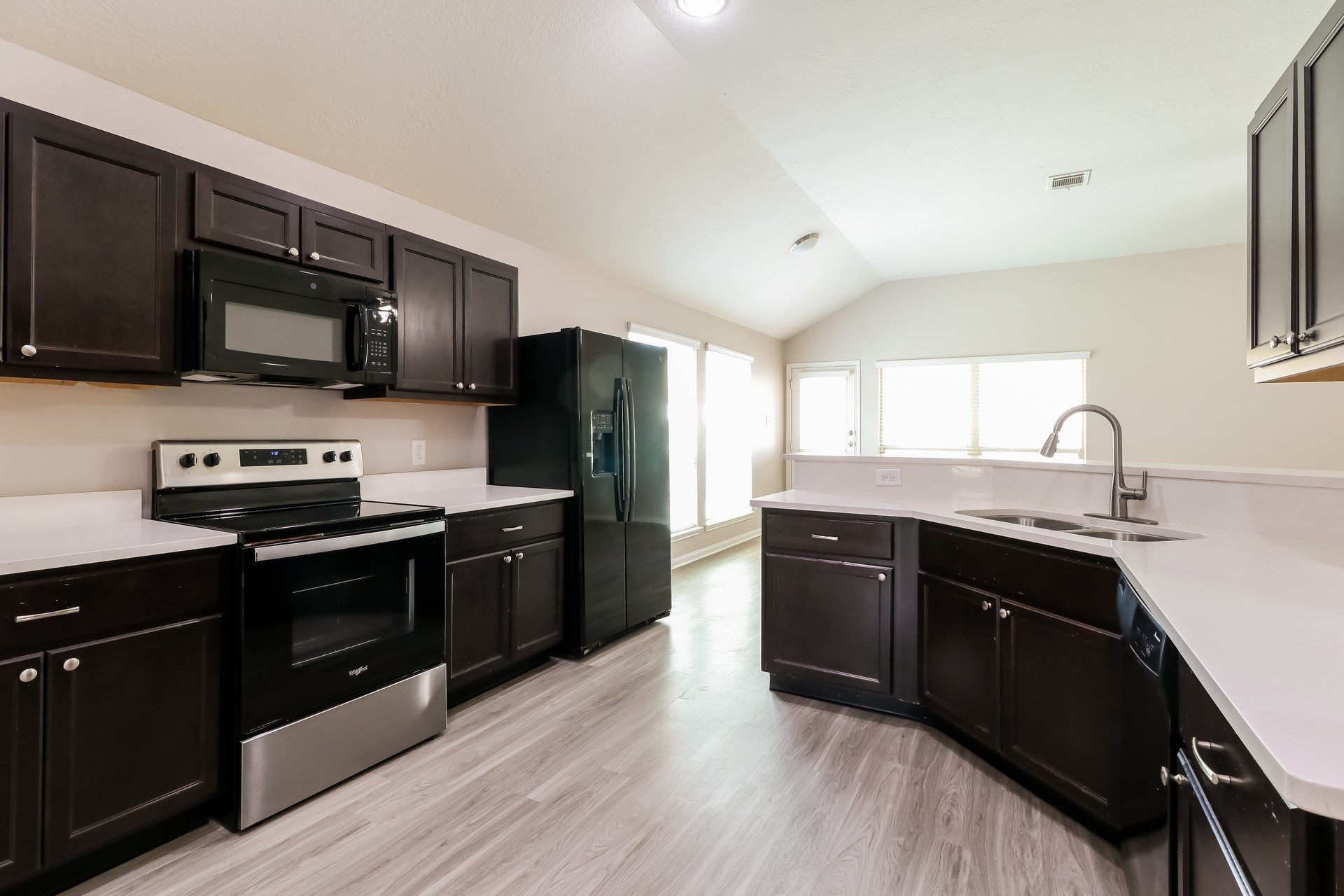 603 Lake View Drive Montgomery, TX 77356 - Photo 7 of 16 a kitchen with stainless steel appliances kitchen island granite countertop a stove a sink dishwasher a refrigerator and a microwave oven with wooden floor