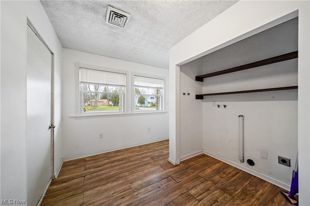 4887 Orchard Road Mentor, OH 44060 - Photo 17 of 26 Laundry room with electric dryer hookup, dark hardwood / wood-style floors, and a textured ceiling