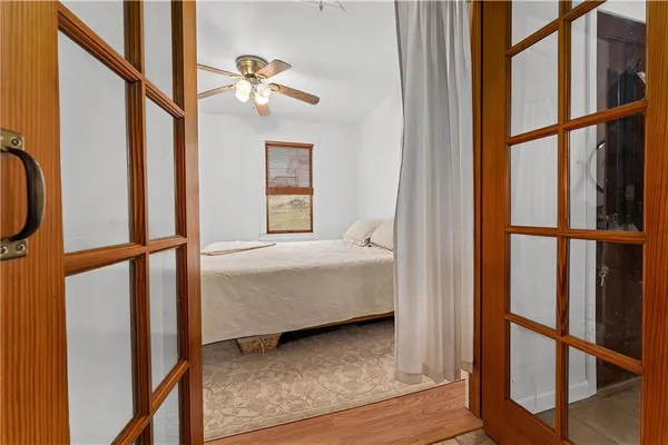 a bedroom with wooden floor and a window
