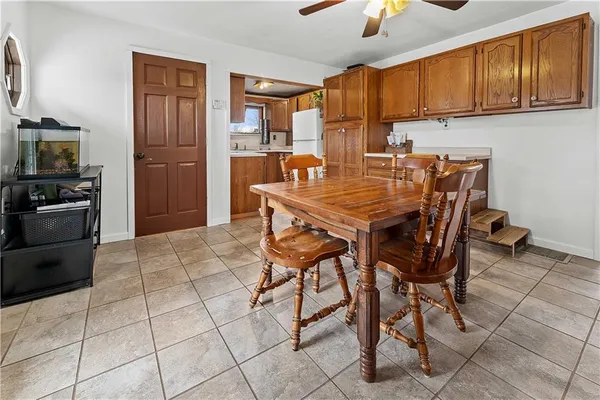 a kitchen with stainless steel appliances kitchen island granite countertop a table chairs and a refrigerator