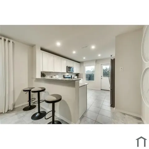 a open kitchen with white cabinets and stainless steel appliances