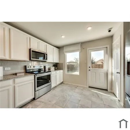 a kitchen with granite countertop a stove a sink and a refrigerator