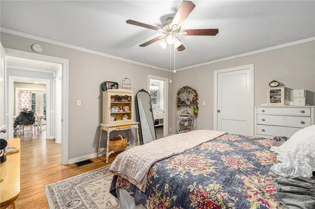a bedroom with a large bed a chandelier and dresser