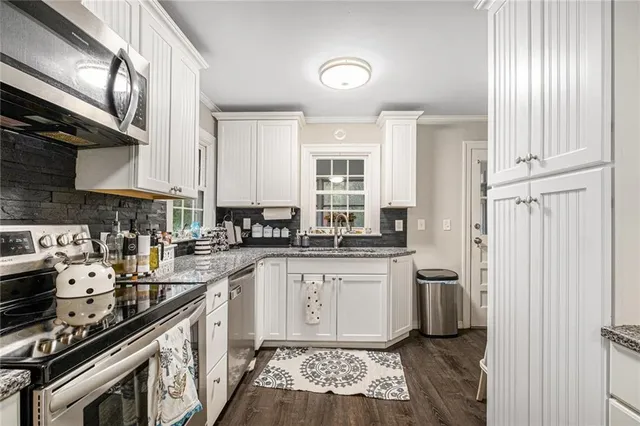 a kitchen with stainless steel appliances a sink stove and cabinets