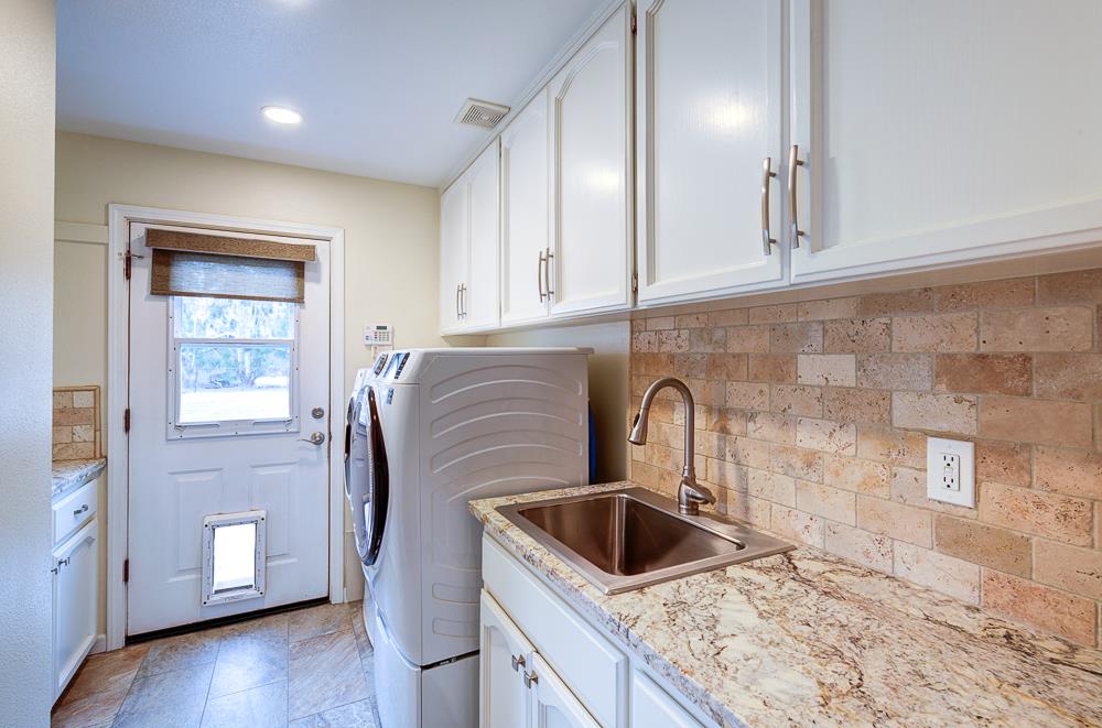 17465 Monreal Road Madera, CA 93636 - Photo 43 of 59 a kitchen with granite countertop a sink a stove and cabinets