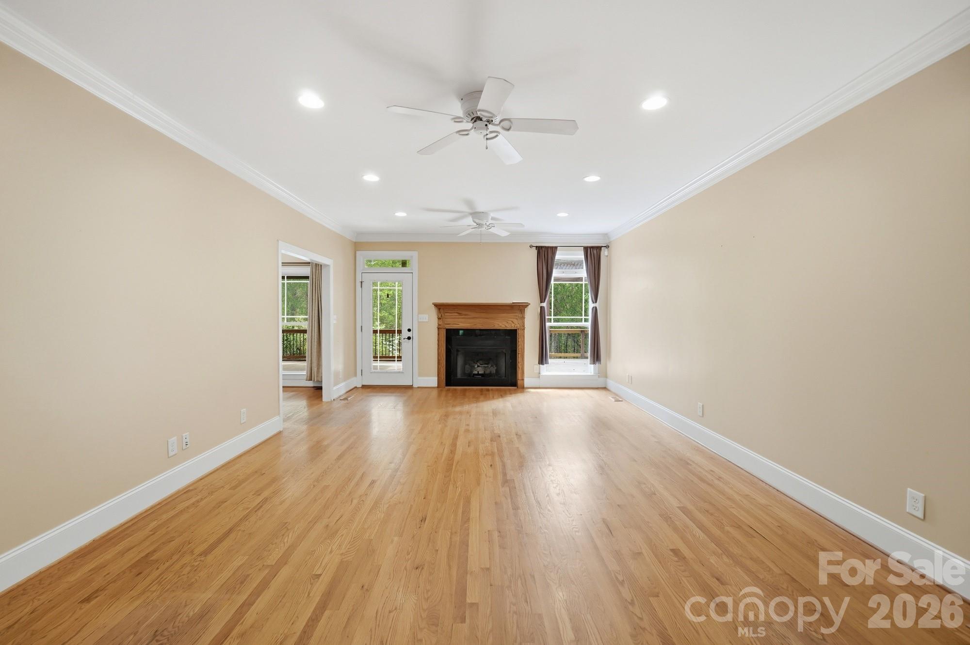 2811 Belk Mill Road Wingate, NC 28174 - Photo 11 of 36 wooden floor fireplace and windows in an empty room