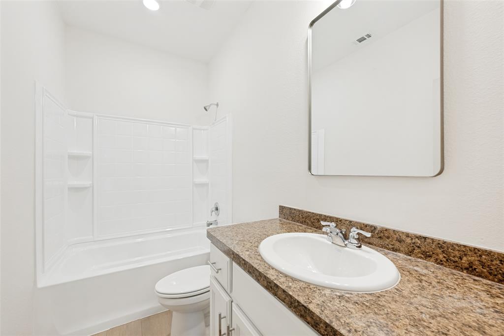 857 Watson Way Crowley, TX 76036 - Photo 21 of 25 Bathroom featuring a white vanity with an undermount sink, granite-finish countertop, and chrome faucet