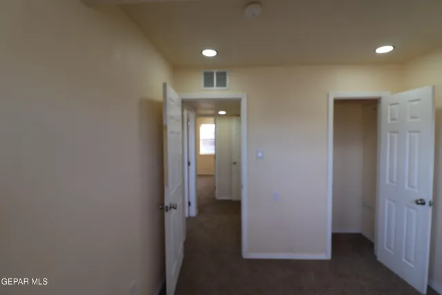 an empty room with windows and closet