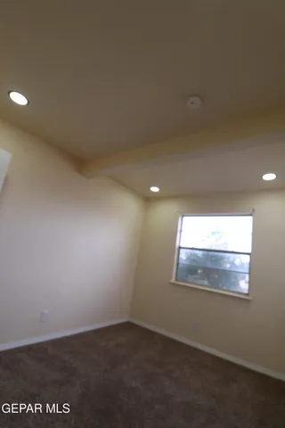 a view of kitchen and empty room with wooden floor