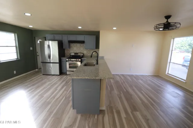 a kitchen with stainless steel appliances granite countertop a sink stove and refrigerator