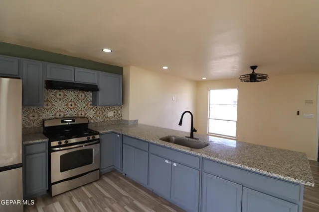 a kitchen with stainless steel appliances granite countertop a sink stove and cabinets