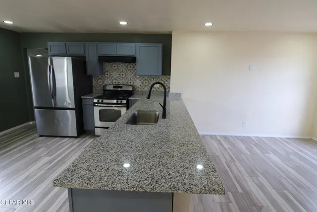 a kitchen with kitchen island a counter top space cabinets and stainless steel appliances