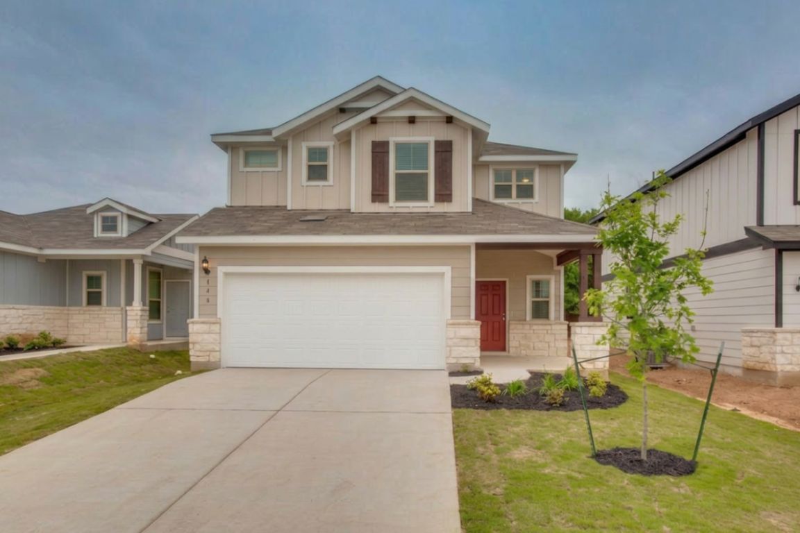 A welcoming facade with a covered entry, stone accents, and a dual-car garage.