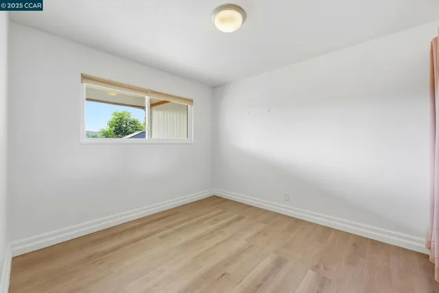 a view of a room with wooden floor and windows