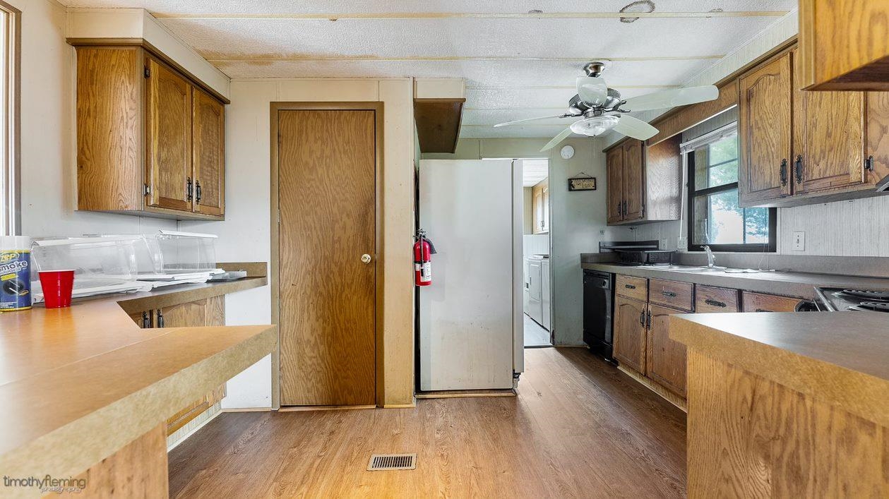 7 Denn Street Rio Grande, NJ 08242 - Photo 9 of 17 a kitchen with stainless steel appliances granite countertop a refrigerator a stove top oven a sink dishwasher and wooden cabinets with wooden floor