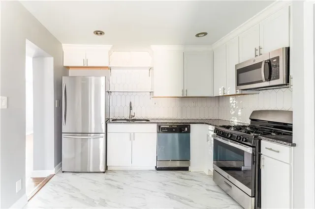 a kitchen with stainless steel appliances granite countertop a refrigerator stove and microwave