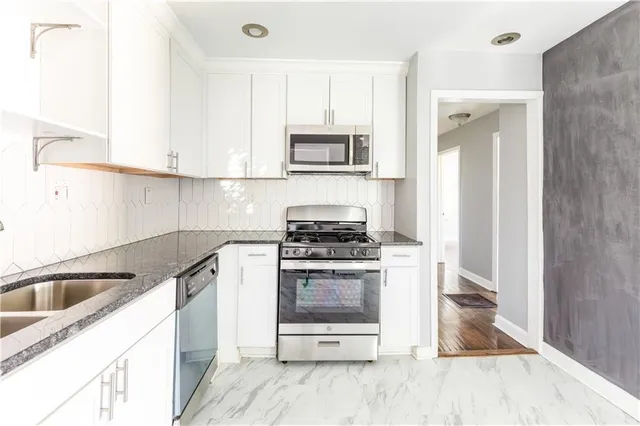 a kitchen with a sink cabinets and stainless steel appliances