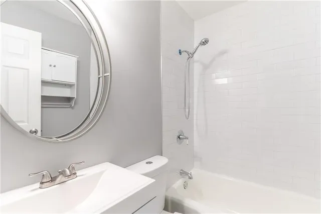 a bathroom with a sink a toilet and a mirror