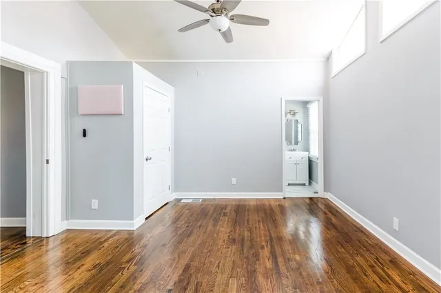 a view of a room with wooden floor and a ceiling fan