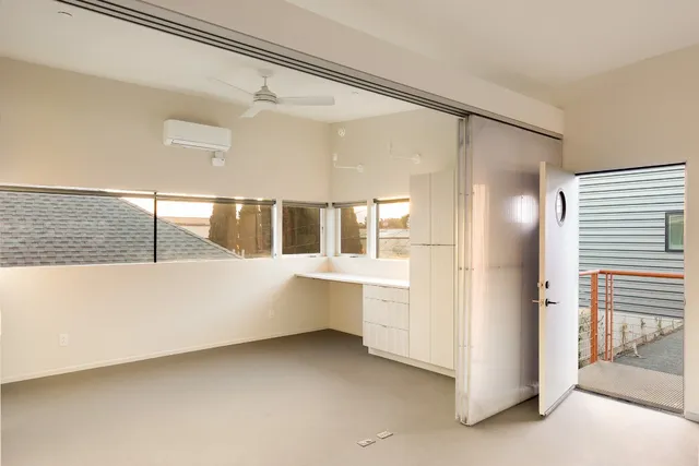 a view of a house with plants and wooden fence