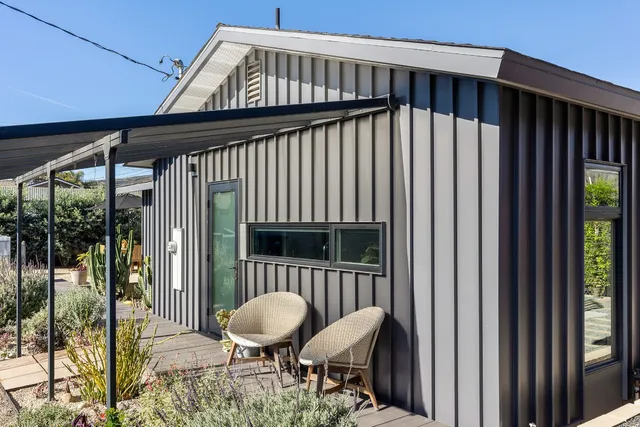 a view of a porch with furniture and a yard