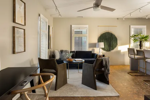 a bedroom with a large bed a chandelier and windows