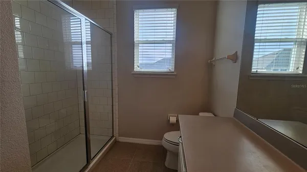 a white toilet sitting in a bathroom next to a window