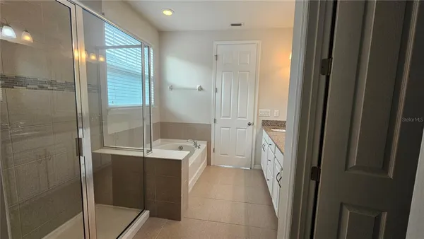 a spacious bathroom with a granite countertop sink a mirror and a shower