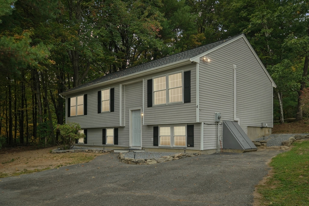 4 Hill Lane Shirley, MA 01464 - Photo 2 of 38 a front view of a house with a yard and garage