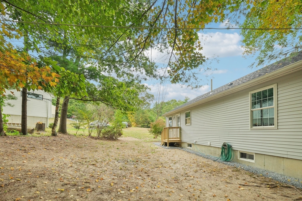 4 Hill Lane Shirley, MA 01464 - Photo 37 of 38 a backyard of a house with large trees and wooden fence