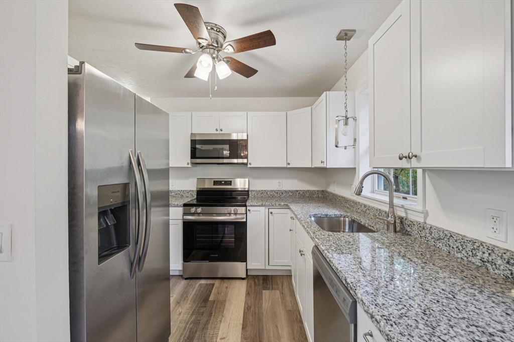 4 Hill Lane Shirley, MA 01464 - Photo 7 of 38 a kitchen with stainless steel appliances granite countertop a sink a stove top oven a refrigerator with island and cabinets