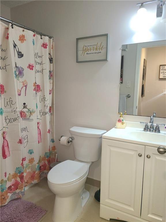 631 Lyons Road, Unit 12205 Coconut Creek, FL 33063 - Photo 10 of 14 a bathroom with a sink toilet and vanity