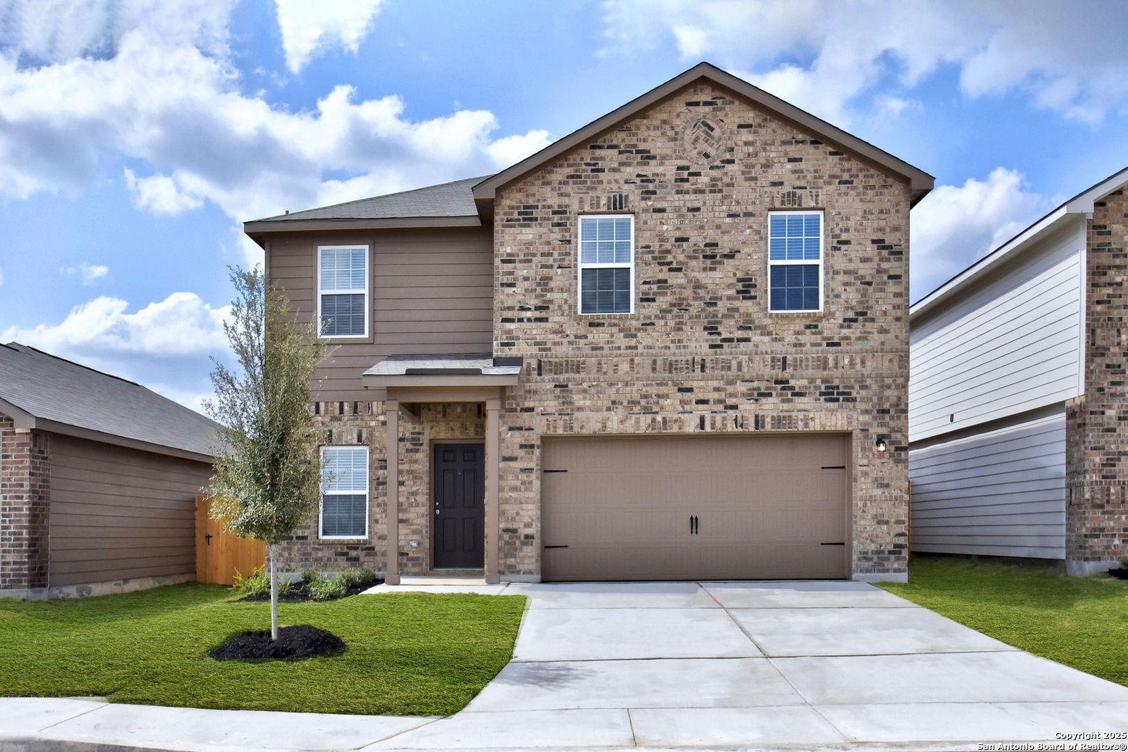 a front view of a house with a yard and garage